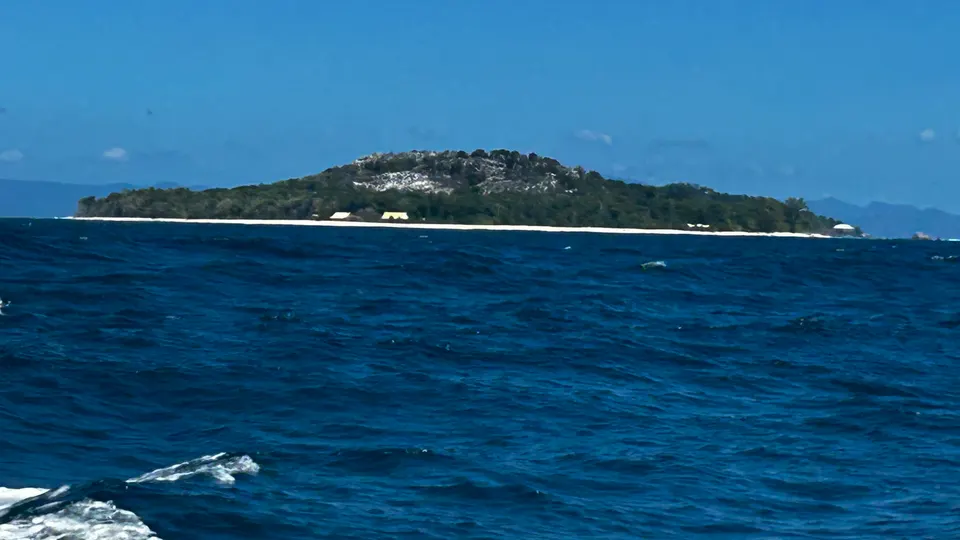 A distant island on the horizon across deep blue water
