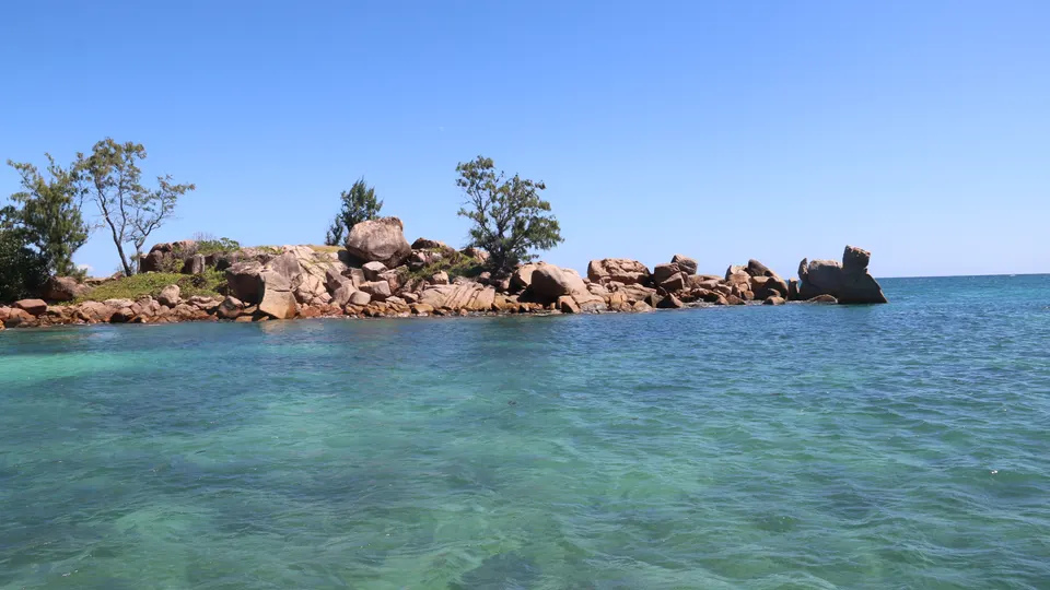 Pink granite boulders at the edge of a shallow lagoon